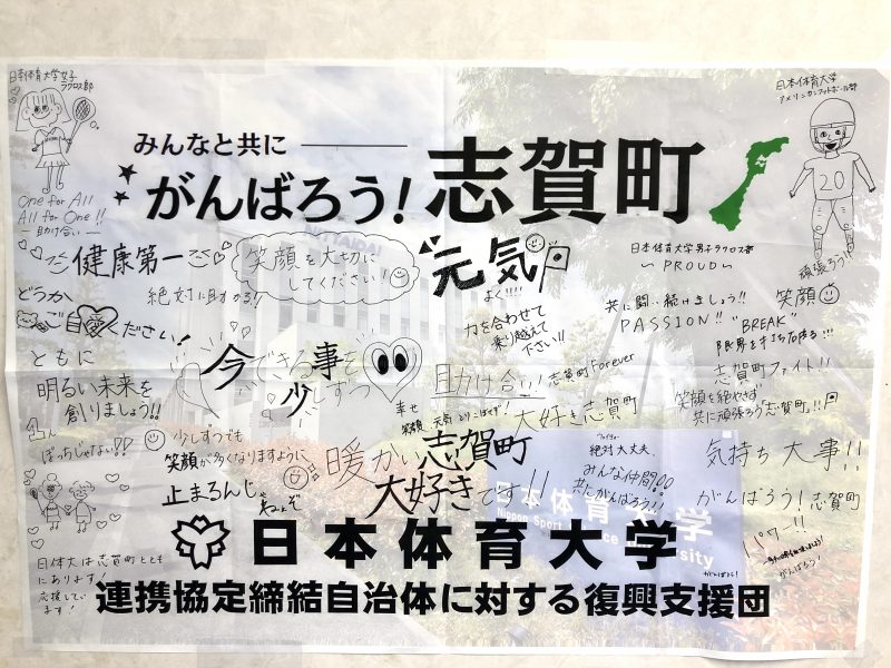 日本体育大学が掲げた復興支援のポスター。地元住民や大学の学生たちからの応援メッセージが書かれており、「がんばろう!志賀町」や「笑顔を大切に!」などの文字が見える。